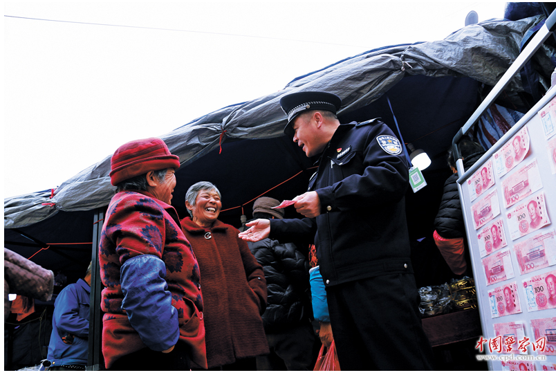 安徽省宁国市公安局霞西派出所民警辅警联合银行工作人员向群众讲解假币鉴别知识