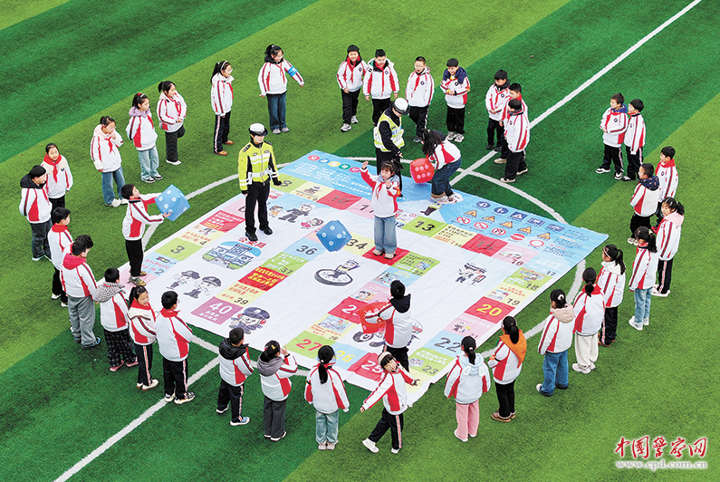 江苏省宝应县公安局交管大队民警与学生开展交通飞行棋互动，学习交通安全知识