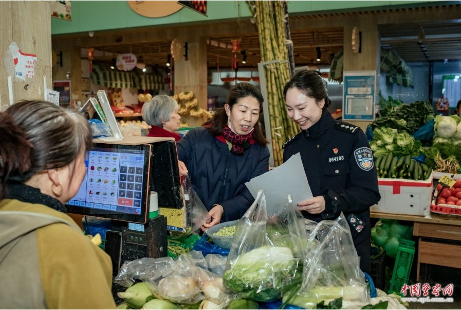 上海市公安局闵行分局民警在农贸市场向老年人宣传安全知识