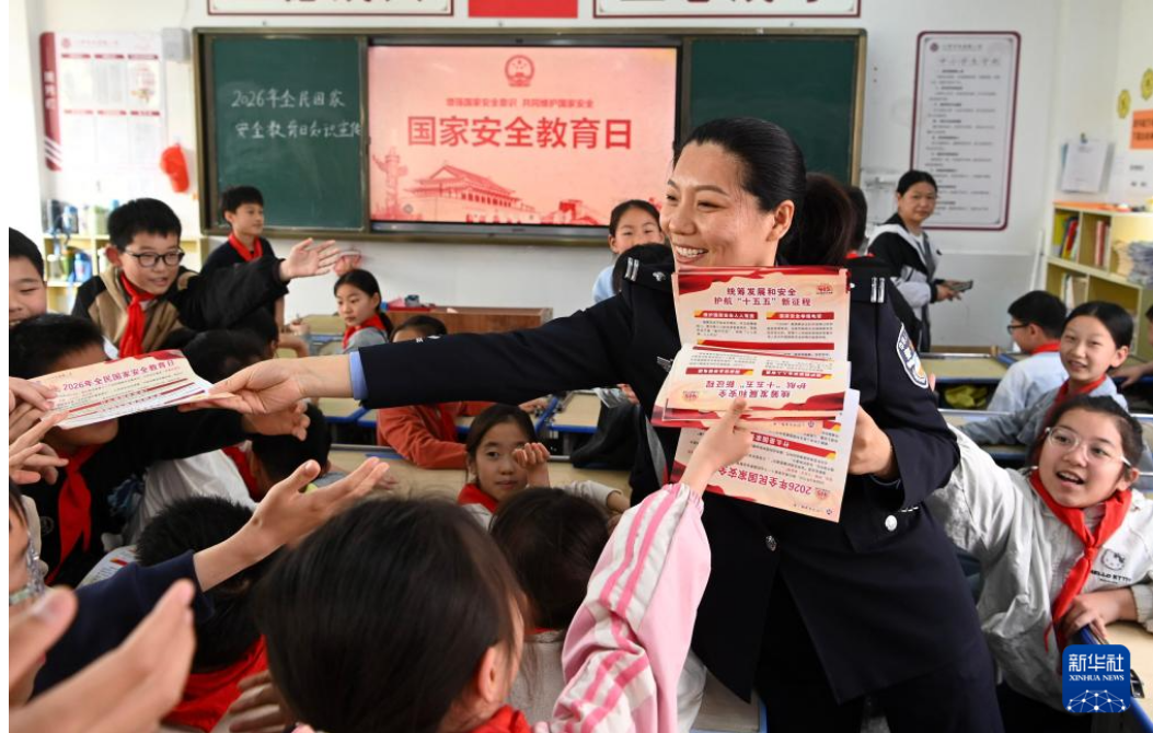 在河南省沁阳市李商隐小学，公安民警为小学生发放国家安全教育宣传资料