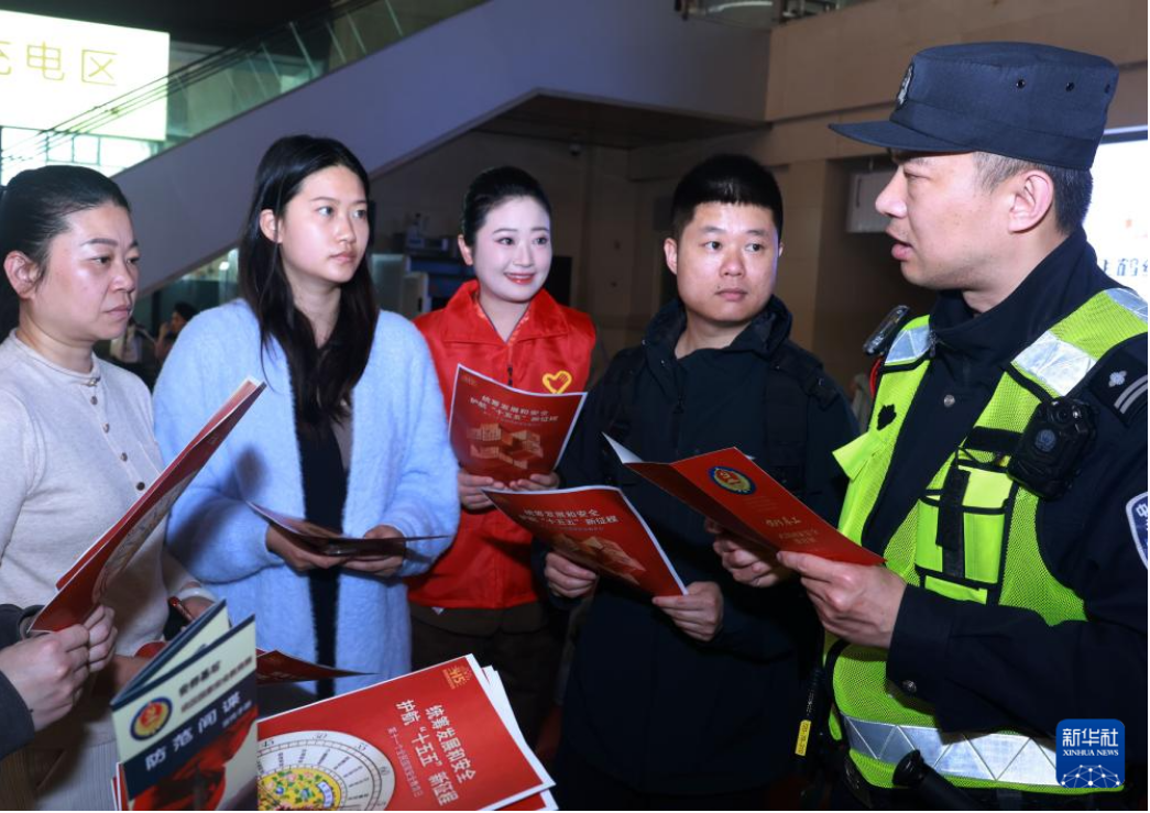 武汉铁路公安处民警、志愿者在湖北省汉口站向旅客宣讲防范化解危害国家安全行为的知识